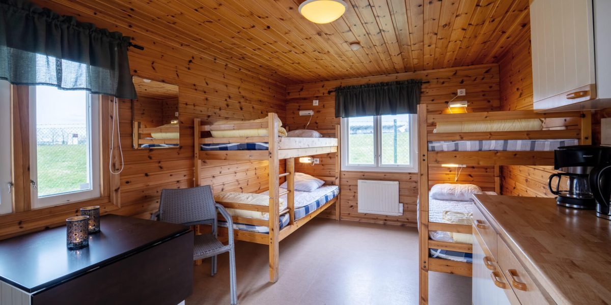 Stuginteriör med våningssängar och bord